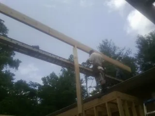Carpenter setting a ridge beam over a new addition frame — Ice Dam Removal by Roofing Brothers in Scottsbluff