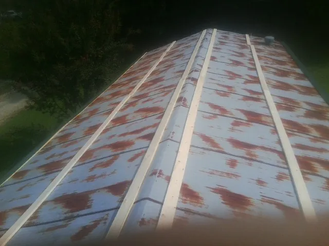 Rusted metal roof panels with new wood purlins before replacement — Storm Damage Roof Repair in Scottsbluff by Roofing Brothers