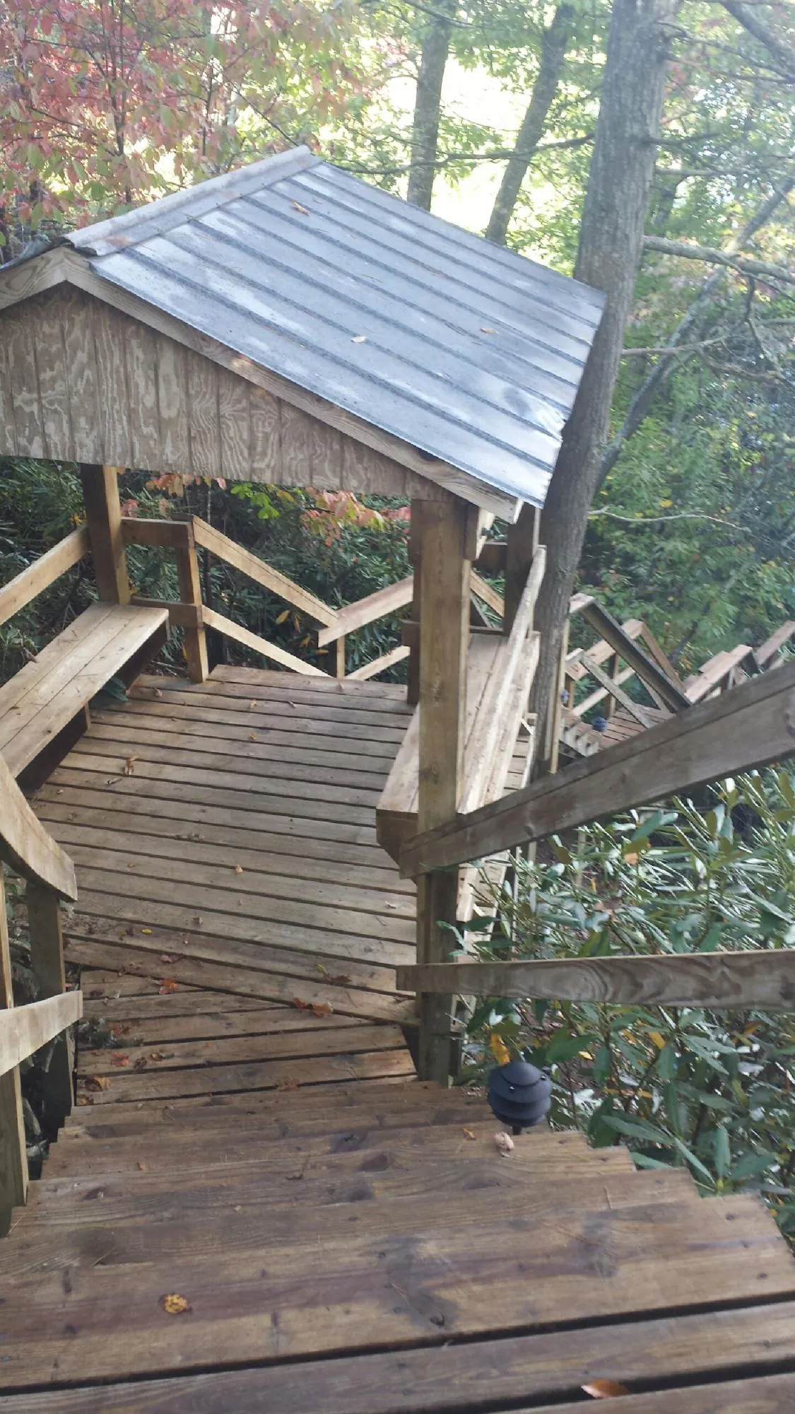 Metal roofed shelter over wooden steps on a wooded walkway — Skylight Repair & Installation work by our crew in Scottsbluff